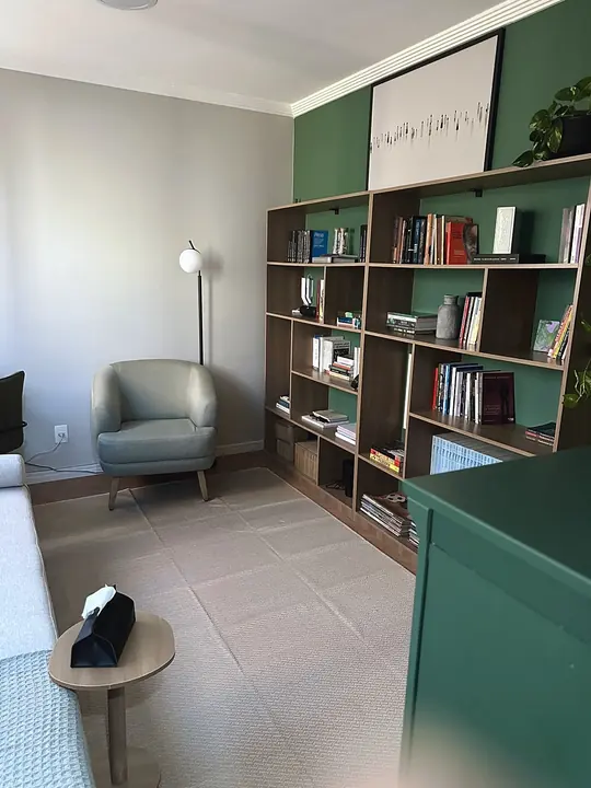 Poltrona e estante de livros na sala de atendimento